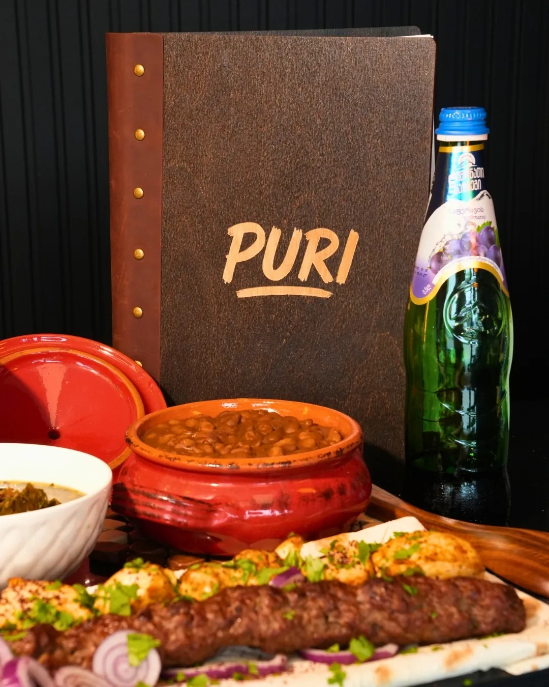 Kebab, beans and Georgian lemonade in front of a leather menu